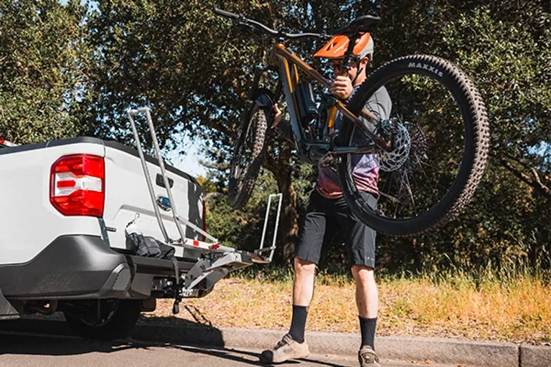 Lifting a lightweight Mrin electric mountain bike onto a car rack