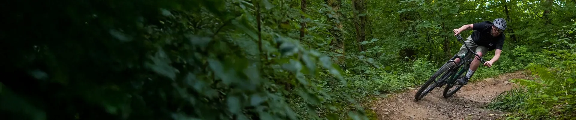 Two Mountain bikers on Merida trail bikes riding a trail through the mountains