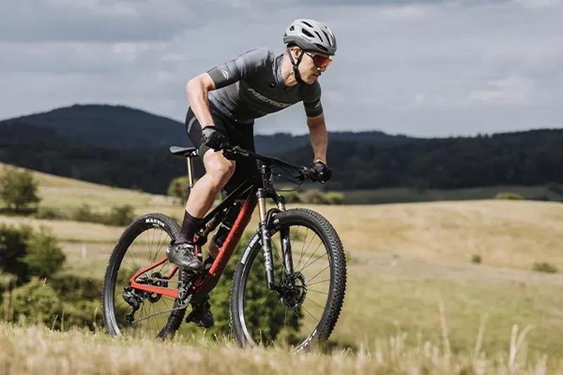 Riding a Merida cross-country mountain bike on wide open track in the hills