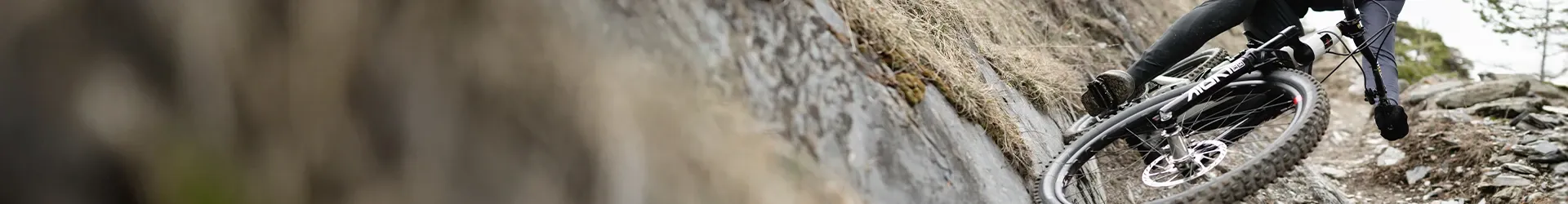 Sant Cruz MTB rider on rock wall closeup with Burgtec padals