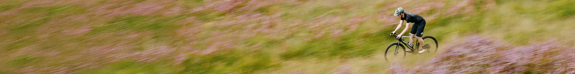 riding a gravel bike down a hill in the autumn pan shot