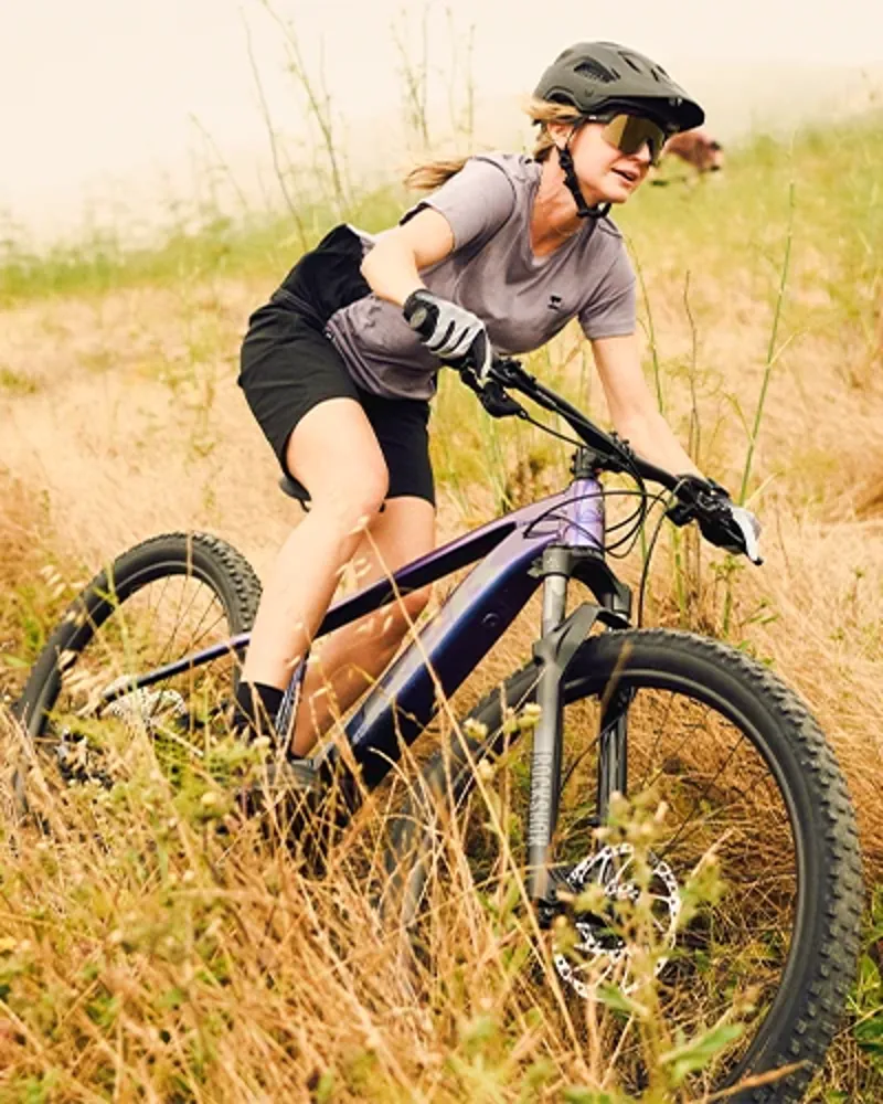 Woman riding the Trek Marlin+ hardtail eMTB on summer trails
